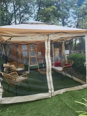 a tent with chairs and a table in a yard at Cabana Exotique Piscine et Jacuzzi in Porto-Vecchio