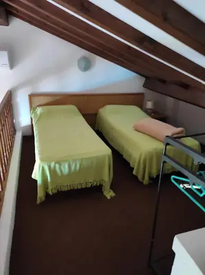 a room with two beds and a chair at Splendide vue Mer in Linguizzetta