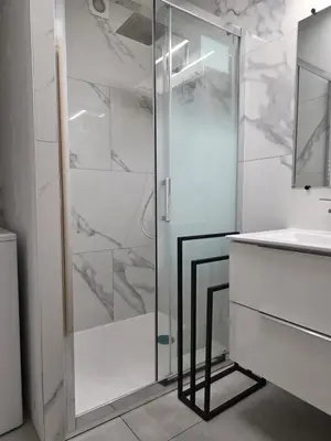 a bathroom with a glass shower and a sink at Splendide vue Mer in Linguizzetta