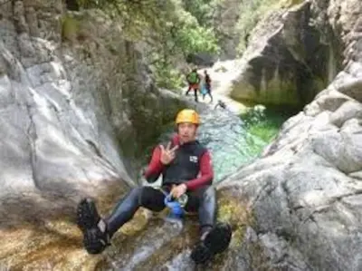 a man sitting on some rocks in a river at Charmant petit logement à 3 kms de la plage in Belgodère