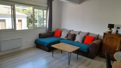 a living room with a couch and a table at Appartement lumineux et central in Propriano