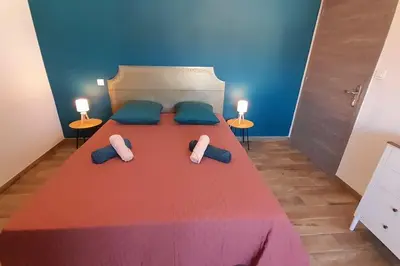 a bedroom with a large bed with two pillows at Appartement lumineux et central in Propriano