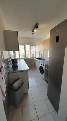 a kitchen with a stainless steel refrigerator and a dishwasher at Appartement lumineux et central in Propriano