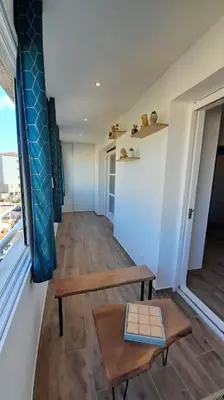 a room with a bench and a table and a window at Appartement lumineux et central in Propriano