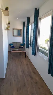 a living room with a table and chairs and windows at Appartement lumineux et central in Propriano