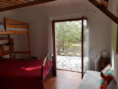 a bedroom with a bed and a sliding glass door at LA MARINE Piscine chauffée villa avec piscine 5 mn à pied de la mer in Solaro