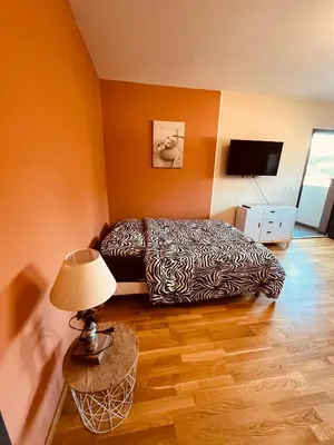 a bedroom with a bed and a table with a lamp at SUPERBE STUDIO AVEC PLACE DE PARKING in Ajaccio
