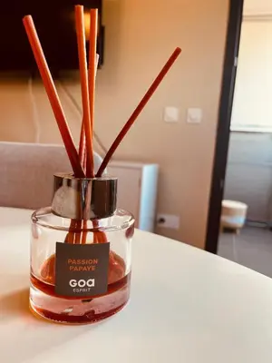 a candle on a table with cinnamon sticks in it at SUPERBE STUDIO AVEC PLACE DE PARKING in Ajaccio