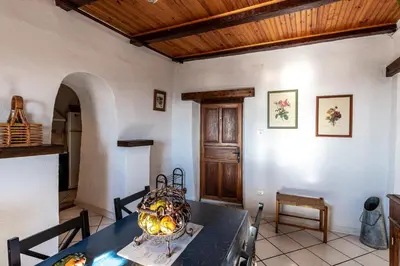 a dining room with a table and a wooden ceiling at Pentone in Cervione
