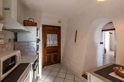 a kitchen with a wooden door and a counter top at Pentone in Cervione