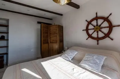 a bedroom with a bed with a wooden wheel on the wall at Pentone in Cervione