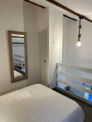 a bedroom with a white bed and a mirror at Maison D Santa Giulia in Porto-Vecchio