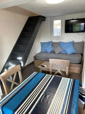 a small living room with a couch and a staircase at Maison D Santa Giulia in Porto-Vecchio