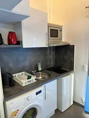 a kitchen with a washing machine and a microwave at Maison D Santa Giulia in Porto-Vecchio