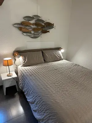a bedroom with a large bed and a lamp at Maison D Santa Giulia in Porto-Vecchio