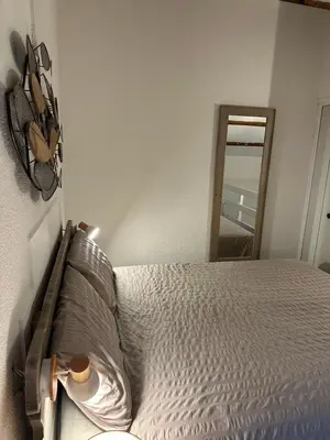 a bedroom with a bed and a mirror at Maison D Santa Giulia in Porto-Vecchio