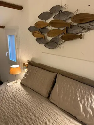 a bedroom with a bed with a surfboard on the wall at Maison D Santa Giulia in Porto-Vecchio