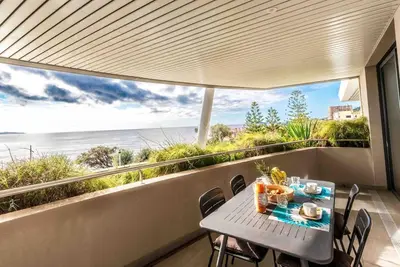 a table and chairs on a balcony with a view of the ocean at Ajaccio, les Cyclades, magnifique appartement vue mer in Ajaccio