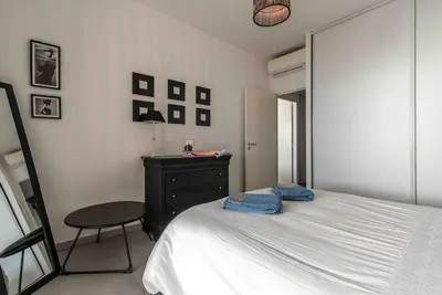 a bedroom with a bed and a desk and a chair at Ajaccio, les Cyclades, magnifique appartement vue mer in Ajaccio