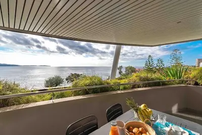 a dining table with a view of the ocean at Ajaccio, les Cyclades, magnifique appartement vue mer in Ajaccio