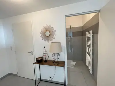 a room with a table with a lamp and a mirror at Ajaccio, les Cyclades, magnifique appartement vue mer in Ajaccio