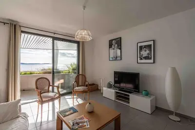 a living room with a couch and a television at Ajaccio, les Cyclades, magnifique appartement vue mer in Ajaccio