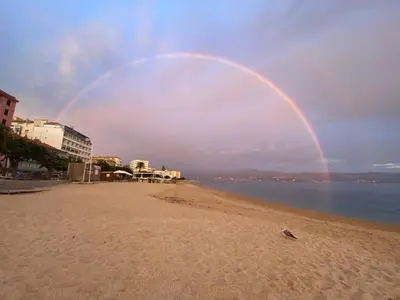 a rainbow in the sky over a beach at Studio neuf et lumineux - Ajaccio centre - Place Miot/Albert 1er in Ajaccio