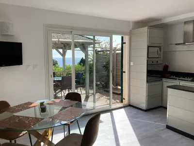 a kitchen and dining room with a glass table at Chez Jean Claude la villa des amis in Olmeto