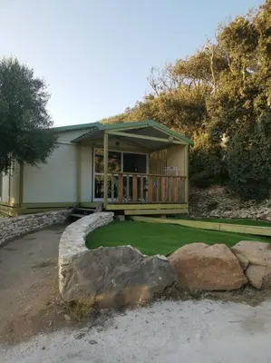 a house with a porch and a yard with rocks at Grande Chambre tout confort 3 in Bonifacio