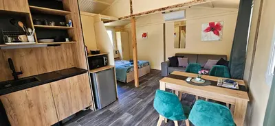 a small room with a kitchen and a table and chairs at Grande Chambre tout confort 3 in Bonifacio