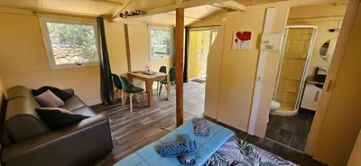 a living room and dining room in a tiny house at Grande Chambre tout confort 3 in Bonifacio