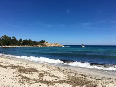 a beach with a boat in the water at Apartment Les Jardins d'Ève-F2 by Interhome in Favone