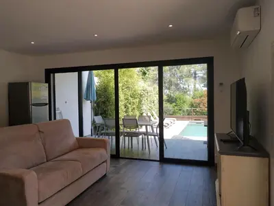 a living room with a couch and a sliding glass door at Apartment Les Jardins d'Ève-F2 by Interhome in Favone