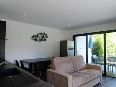 a living room with a couch and a table at Apartment Les Jardins d'Ève-F2 by Interhome in Favone