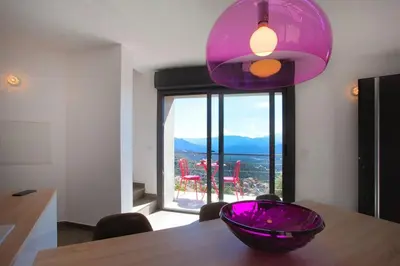 a purple bowl sitting on a wooden table with a window at Le SAN PETRONE-TOUR EN PIERRE EN CENTRE CORSE ENTRE MER ET MONTAGNE in Moltifao
