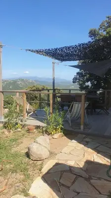 a patio with a table and a view of the mountains at Meublé de tourisme avec terrasse vue montagne in Grossa