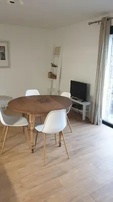 a wooden table and chairs in a living room at Meublé de tourisme avec terrasse vue montagne in Grossa
