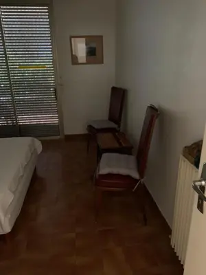 a room with two chairs and a bed and a window at Casa Rossa Solenzara in Sari Solenzara