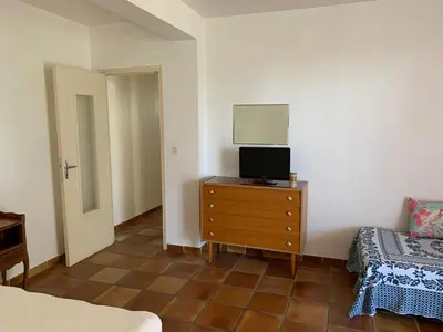 a bedroom with a bed and a dresser with a television at Casa Rossa Solenzara in Sari Solenzara