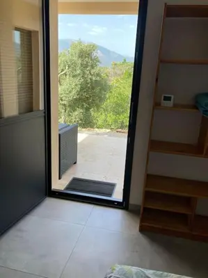 a door to a room with a view of a porch at T1 traversant, plain pied entre mer et montagne in Cuttoli-Corticchiato