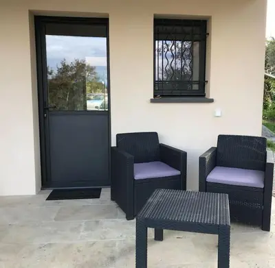 two chairs and a table in front of a door at T1 traversant, plain pied entre mer et montagne in Cuttoli-Corticchiato