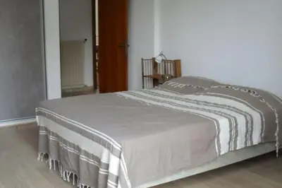 a bedroom with a bed with a white blanket on it at Appartement 8 pers. - Domaine de Padulone ALERIA in Aléria