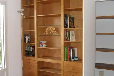 a wooden book shelf with books on it at Appartement 8 pers. - Domaine de Padulone ALERIA in Aléria
