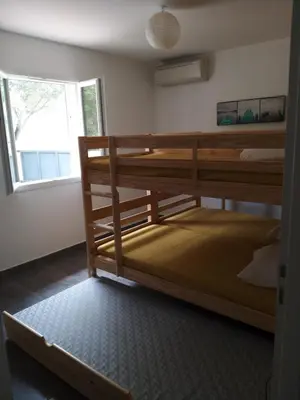a room with two bunk beds and a window at Villa climatisée avec piscine in Sari Solenzara