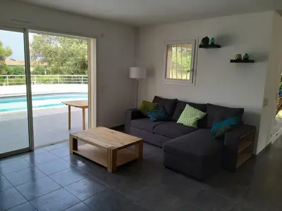 a living room with a couch and a coffee table at Villa climatisée avec piscine in Sari Solenzara