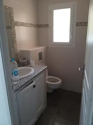 a bathroom with a sink and a toilet and a window at Villa climatisée avec piscine in Sari Solenzara