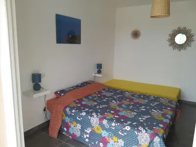 a bedroom with a bed with a colorful comforter at Villa climatisée avec piscine in Sari Solenzara