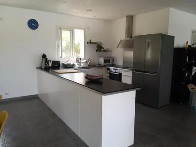 a kitchen with a counter top and a refrigerator at Villa climatisée avec piscine in Sari Solenzara