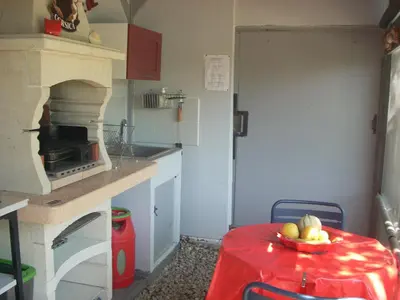 a kitchen with a table with a bowl of fruit on it at CHAMBRE INDEPENDANTE climatisée, cuisine d'été, piscine in Sartène