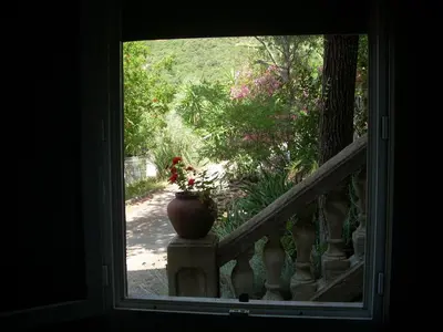 a window view of a stairway with a vase at CHAMBRE INDEPENDANTE climatisée, cuisine d'été, piscine in Sartène